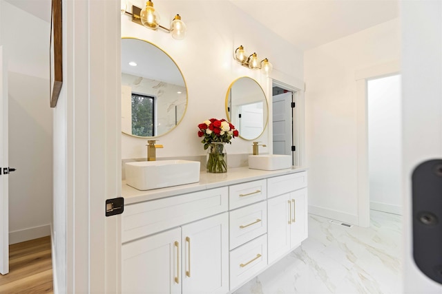 bathroom with baseboards, marble finish floor, and a sink