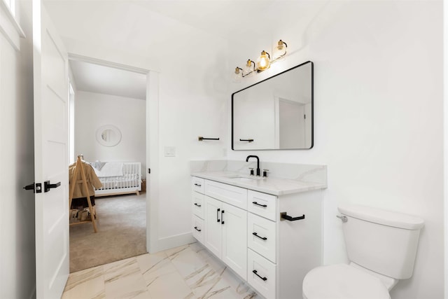 ensuite bathroom with vanity, baseboards, ensuite bathroom, toilet, and marble finish floor