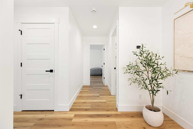 hall featuring recessed lighting, baseboards, and light wood finished floors