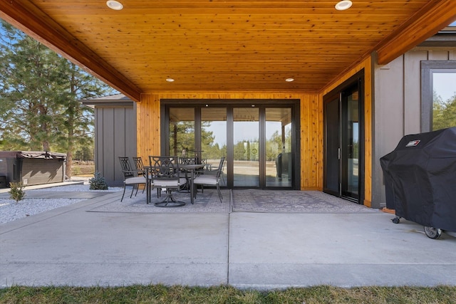 view of patio / terrace with area for grilling, a hot tub, and outdoor dining area