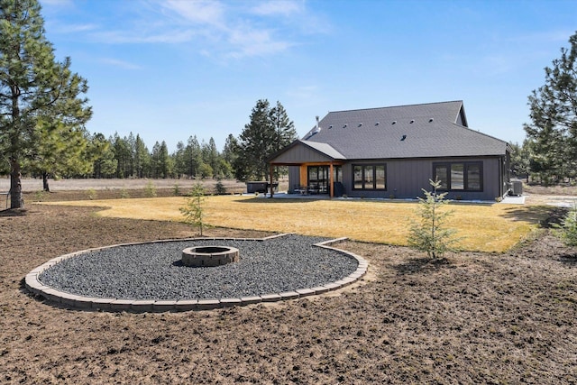 rear view of house with a patio, a fire pit, and a lawn