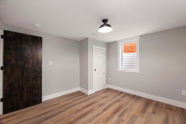 unfurnished bedroom featuring light wood-style flooring, visible vents, and baseboards