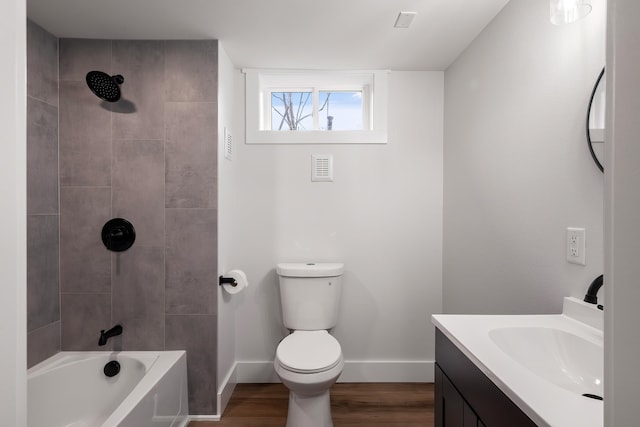 full bath with baseboards, toilet, shower / bathing tub combination, wood finished floors, and vanity