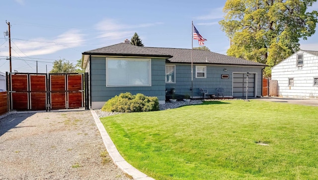 rear view of house with a gate, a lawn, fence, and roof with shingles