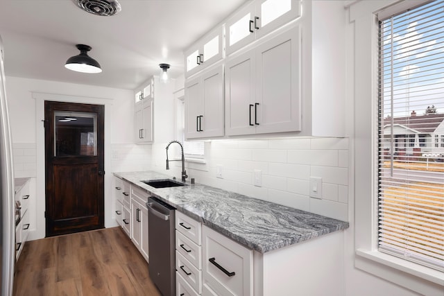 kitchen with visible vents, a sink, white cabinets, glass insert cabinets, and dishwasher