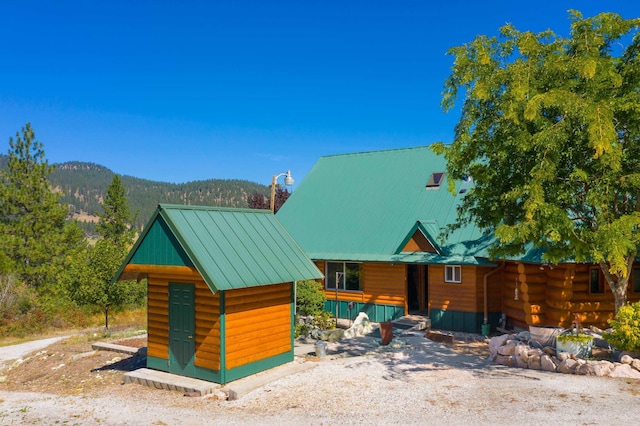 view of front of home featuring a mountain view and an outdoor structure