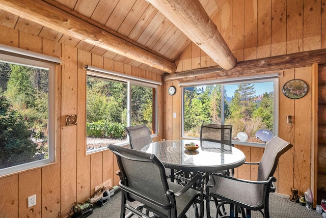 carpeted dining room featuring wooden ceiling, vaulted ceiling with beams, and wood walls