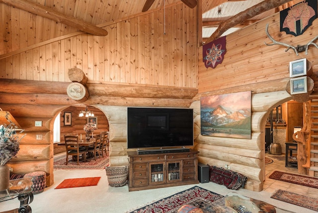 living area with log walls, an inviting chandelier, beam ceiling, arched walkways, and wooden ceiling