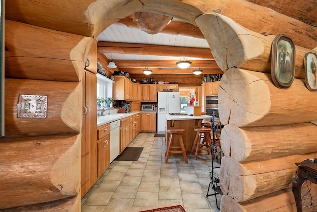 kitchen with beam ceiling, a breakfast bar, a sink, stainless steel appliances, and light countertops