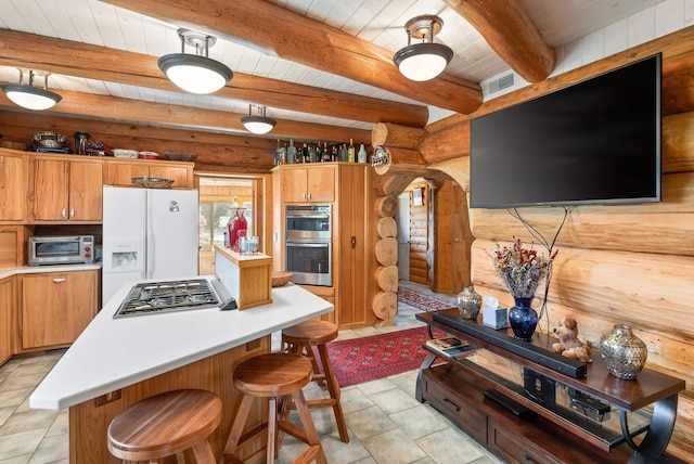 kitchen featuring a center island, a toaster, light countertops, appliances with stainless steel finishes, and wooden ceiling