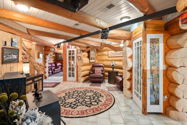 living room with tile patterned floors, visible vents, beamed ceiling, and french doors