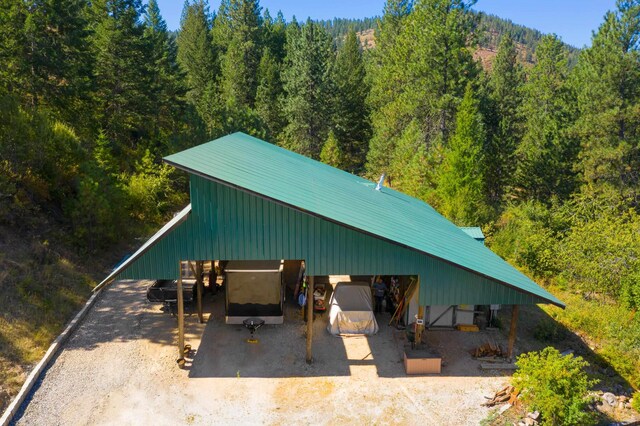 exterior space featuring a carport and a wooded view