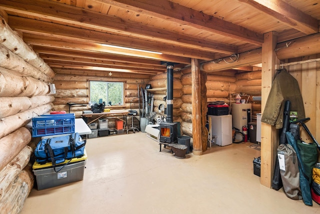 basement with electric water heater and a wood stove