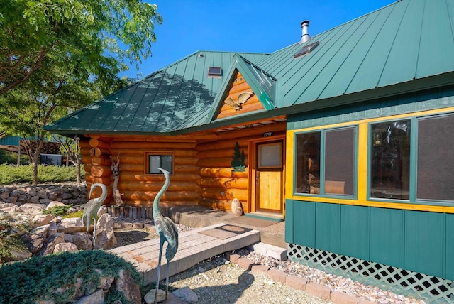 exterior space featuring metal roof, log exterior, and a standing seam roof