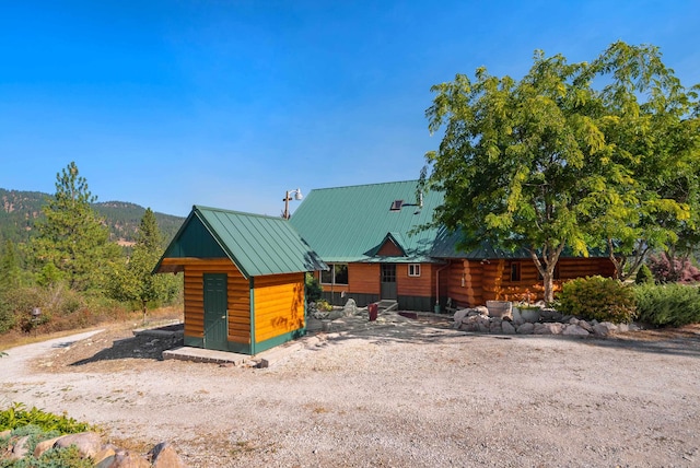 exterior space featuring an outbuilding, a shed, metal roof, and a standing seam roof