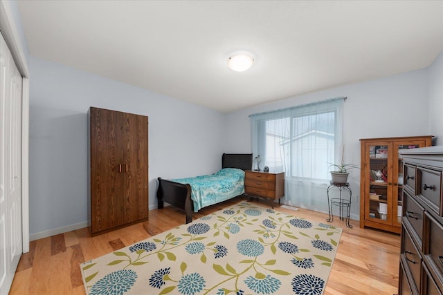 bedroom featuring a closet, baseboards, and light wood-style floors