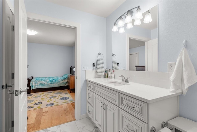 ensuite bathroom with marble finish floor, ensuite bath, and vanity