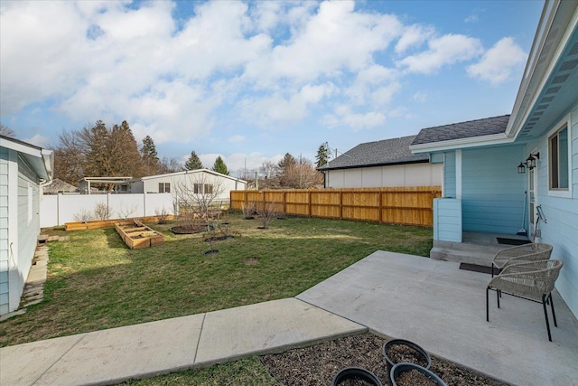 view of yard featuring a fenced backyard, a patio, and a vegetable garden