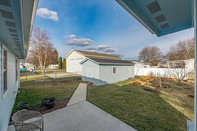 view of yard with a patio, fence, a shed, a vegetable garden, and an outdoor structure