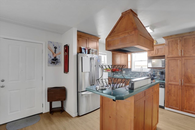 kitchen featuring island exhaust hood, decorative backsplash, appliances with stainless steel finishes, and light wood finished floors