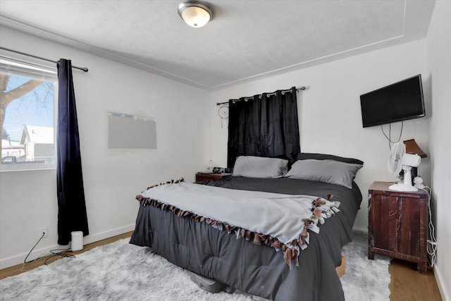 bedroom with baseboards and wood finished floors