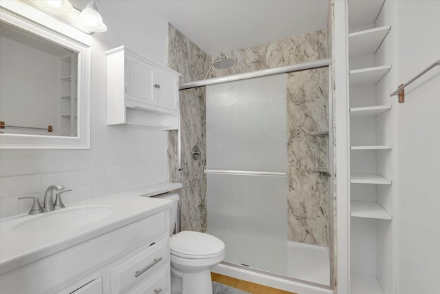 bathroom featuring vanity, toilet, and a stall shower