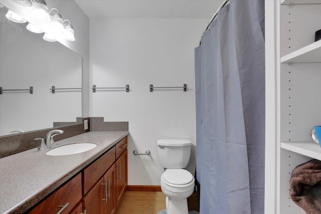 full bath with baseboards, toilet, a shower with shower curtain, wood finished floors, and vanity