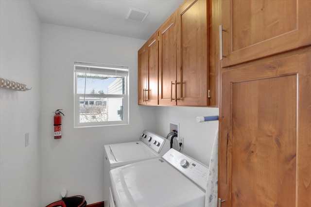 washroom featuring visible vents, cabinet space, and separate washer and dryer