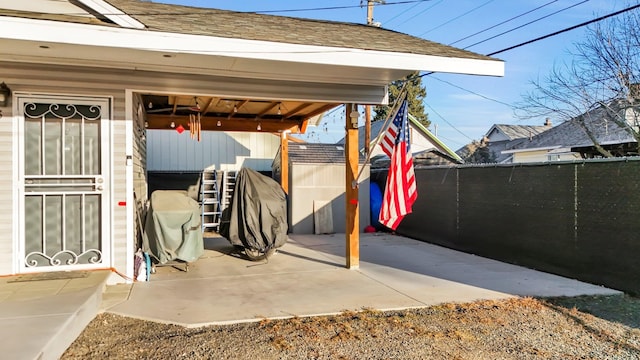 view of patio featuring an outbuilding and fence