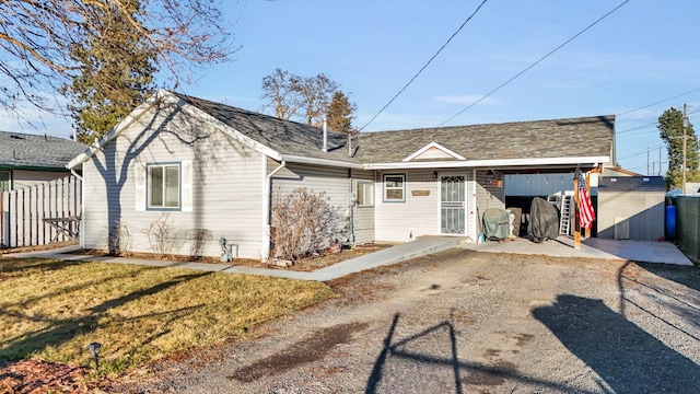 view of front of house with roof with shingles, a front lawn, and fence