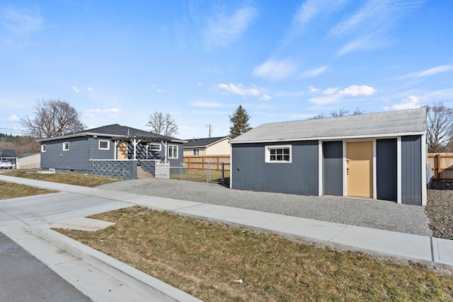 view of front of property featuring an outbuilding and fence