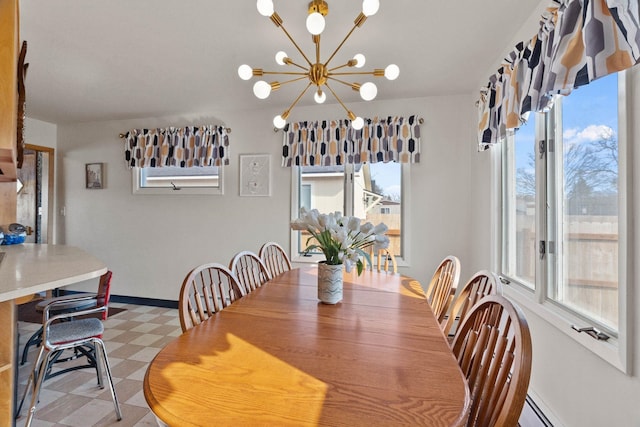 dining area with light floors, a healthy amount of sunlight, an inviting chandelier, and a baseboard radiator