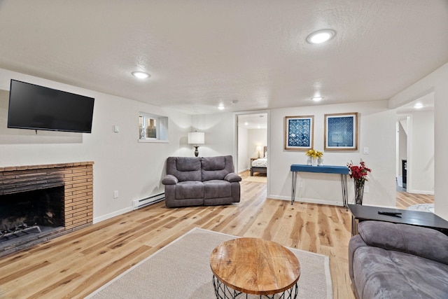 living area with baseboards, baseboard heating, wood finished floors, and a textured ceiling