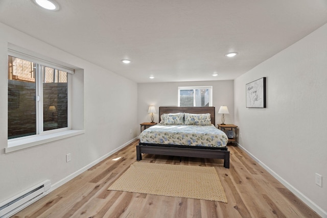 bedroom with recessed lighting, light wood-type flooring, a baseboard heating unit, and baseboards