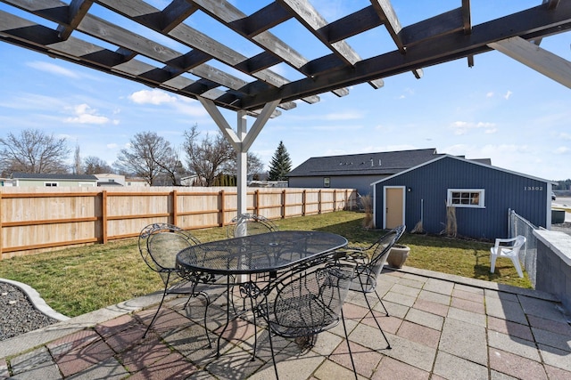 view of patio with an outbuilding, outdoor dining area, a fenced backyard, and a pergola