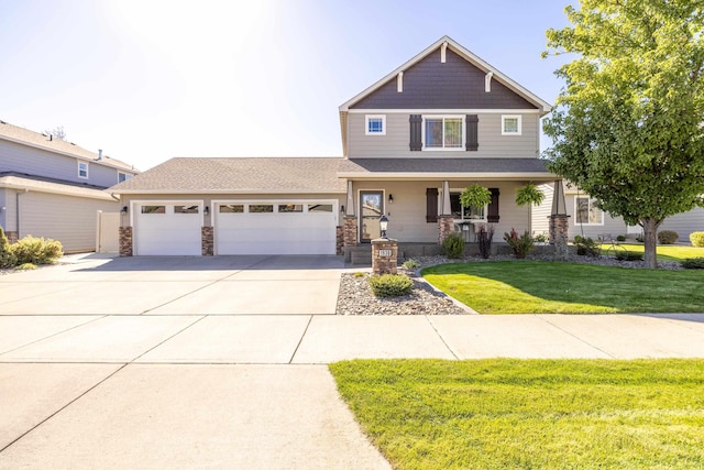 craftsman-style house with a front lawn, a porch, concrete driveway, a garage, and stone siding