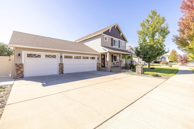 view of front of house featuring a garage, a porch, concrete driveway, and stone siding