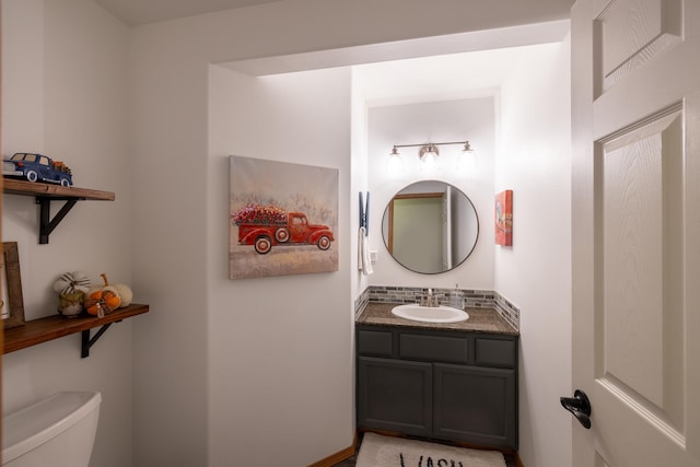 bathroom featuring tasteful backsplash, toilet, and vanity