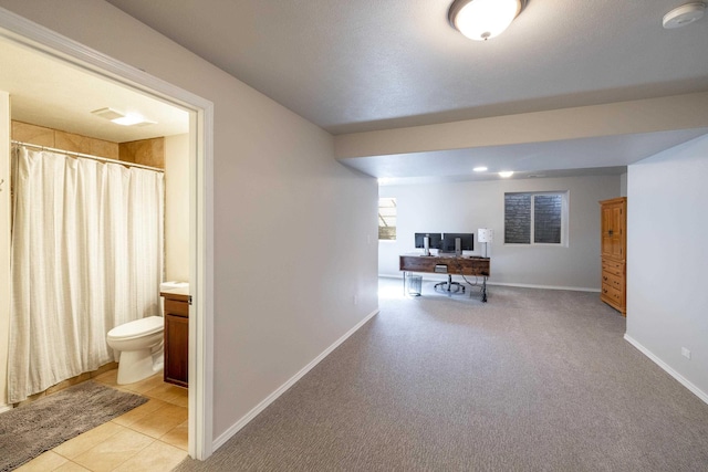 interior space with light tile patterned flooring, baseboards, and light carpet