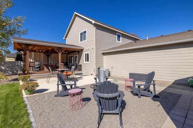 rear view of house with a patio area, fence, and an outdoor fire pit