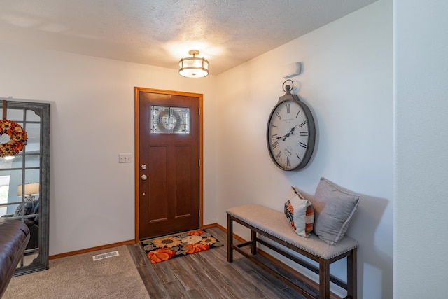 entrance foyer with visible vents, baseboards, a textured ceiling, and dark wood-style flooring