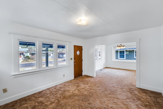 carpeted empty room with baseboards