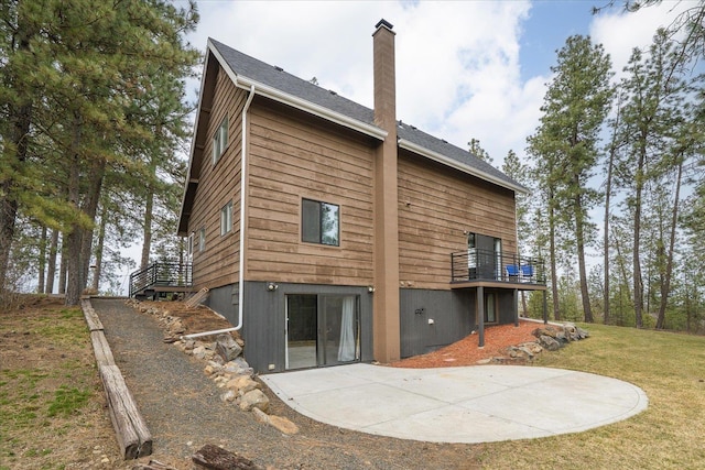 back of house with a patio area, a lawn, a chimney, and a deck