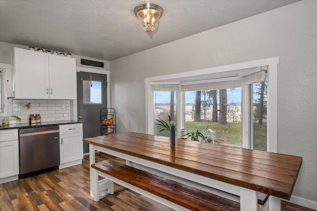 dining area featuring visible vents, a textured ceiling, and dark wood-type flooring