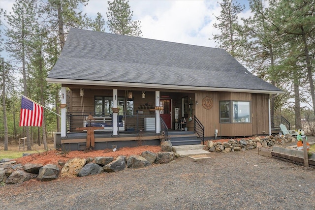 view of front of home with roof with shingles and a porch