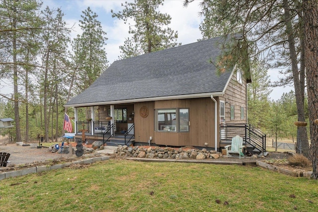 chalet / cabin featuring a front yard and a shingled roof