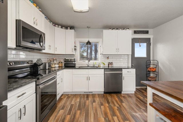 kitchen featuring a sink, stainless steel appliances, a wealth of natural light, and dark wood finished floors