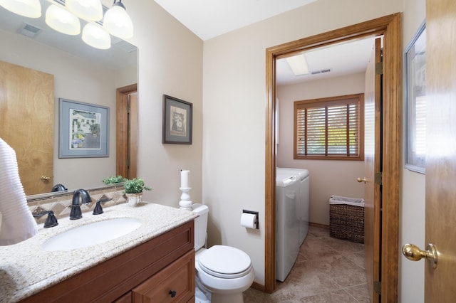 bathroom with visible vents, toilet, vanity, and separate washer and dryer