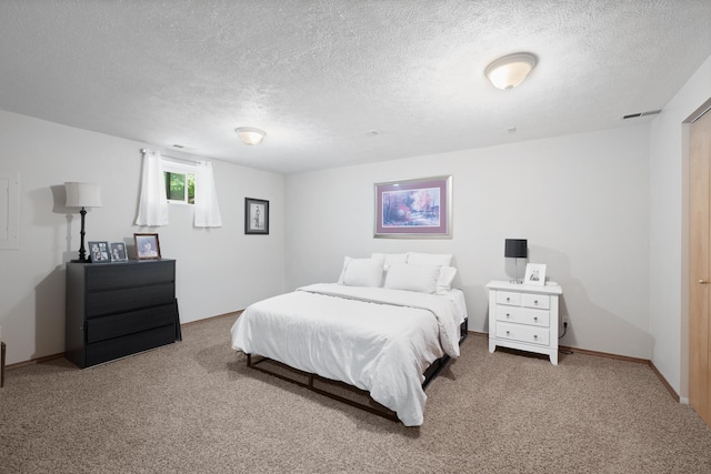 bedroom with visible vents, a textured ceiling, baseboards, and carpet floors