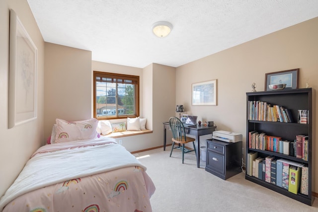 bedroom featuring light colored carpet, a textured ceiling, and baseboards